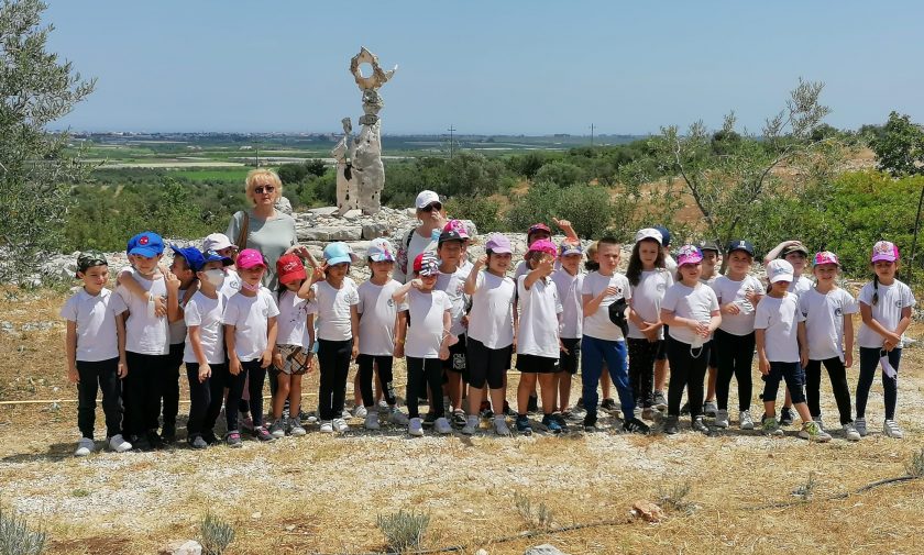Foto di gruppo con bambini; campagna, sole, statua di pietra