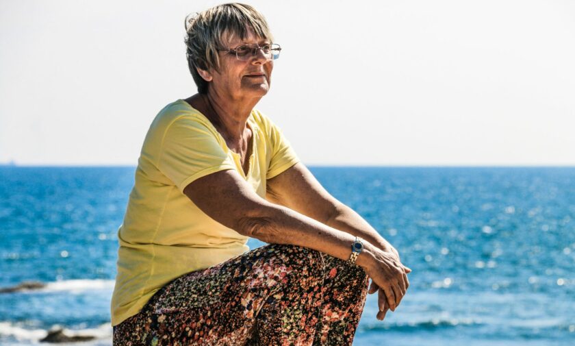 donna anziana al sole, sulla spiaggia