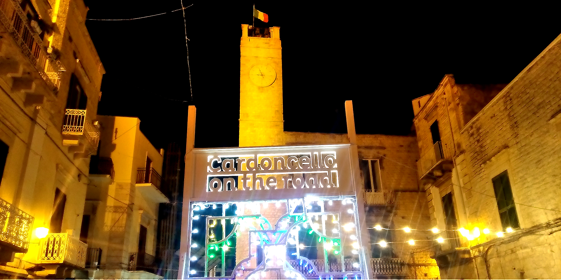 torre dell'orologio, luminaria che circonda la scritta "Cardoncello on the road"